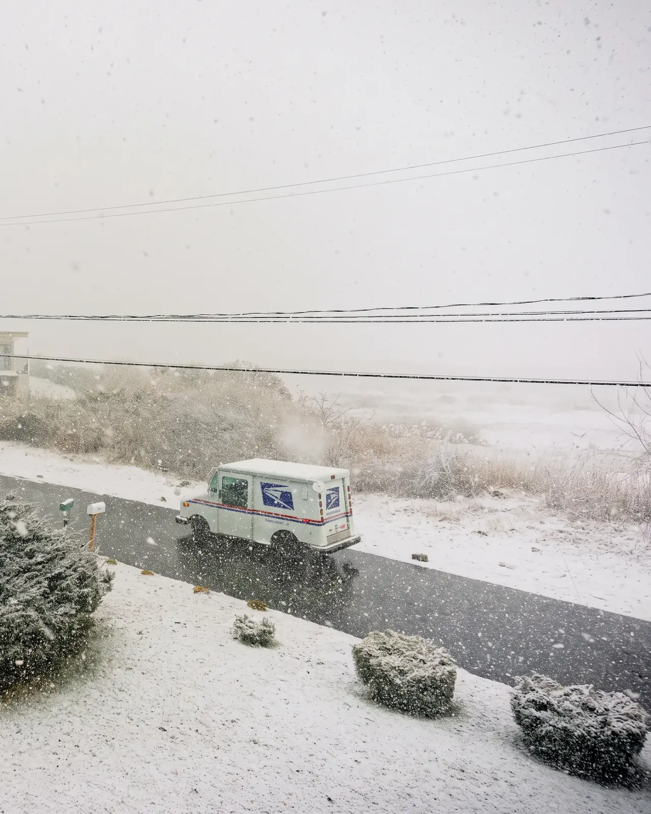 A USPS truck bound for delivery under snow